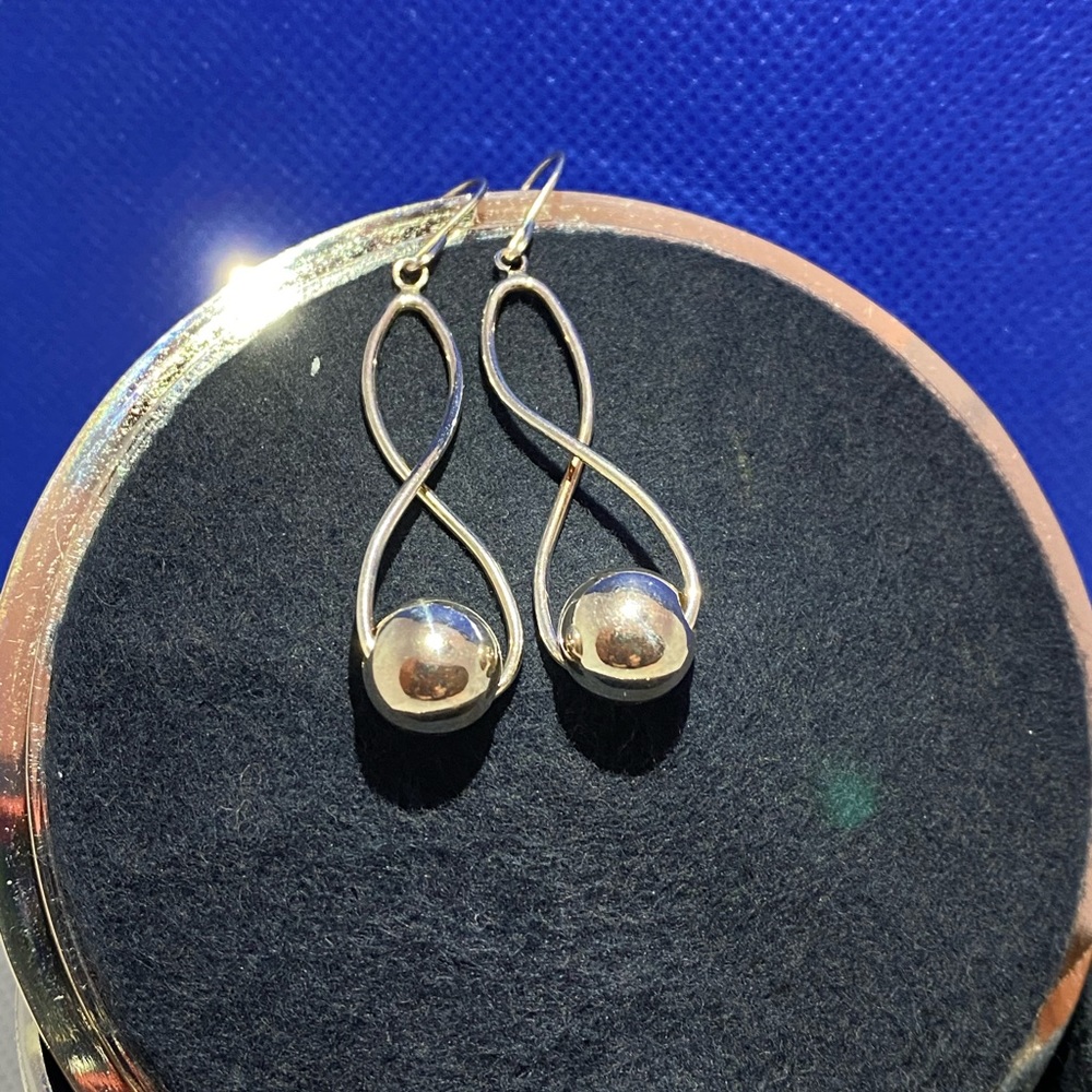 Silver earrings that dangle with a ball accent